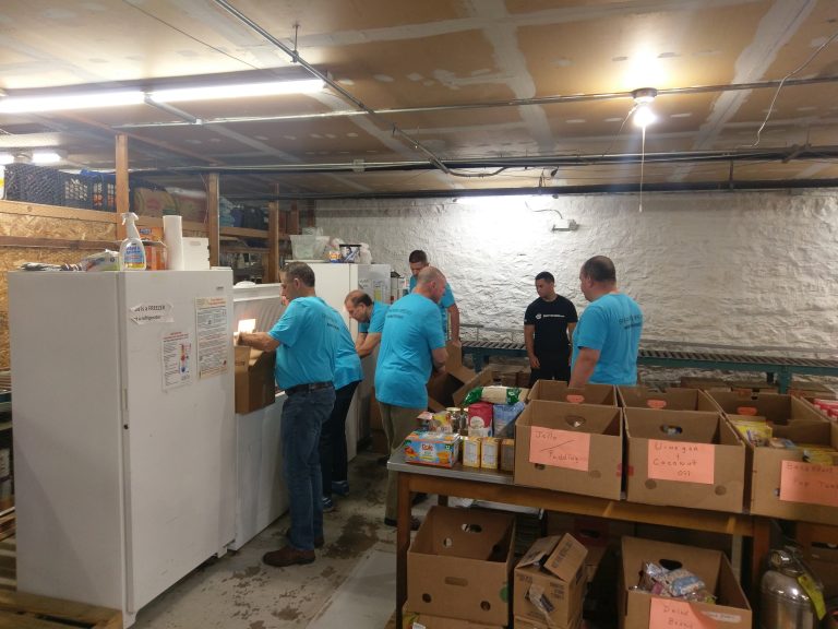 Group of volunteer workers boxing up non-perishable food items.