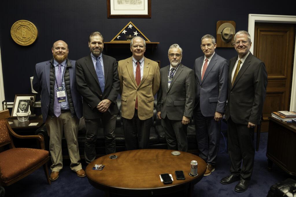 Mediacom's Mitchell Brown; GCI's David Hymas, Rep. Guthrie; Broadlinc's TJ Scott; Murray Electric's Chad Lawson; and ACA Connects' Grant Spellmeyer pose for a quick photo after discussing broadband policy.